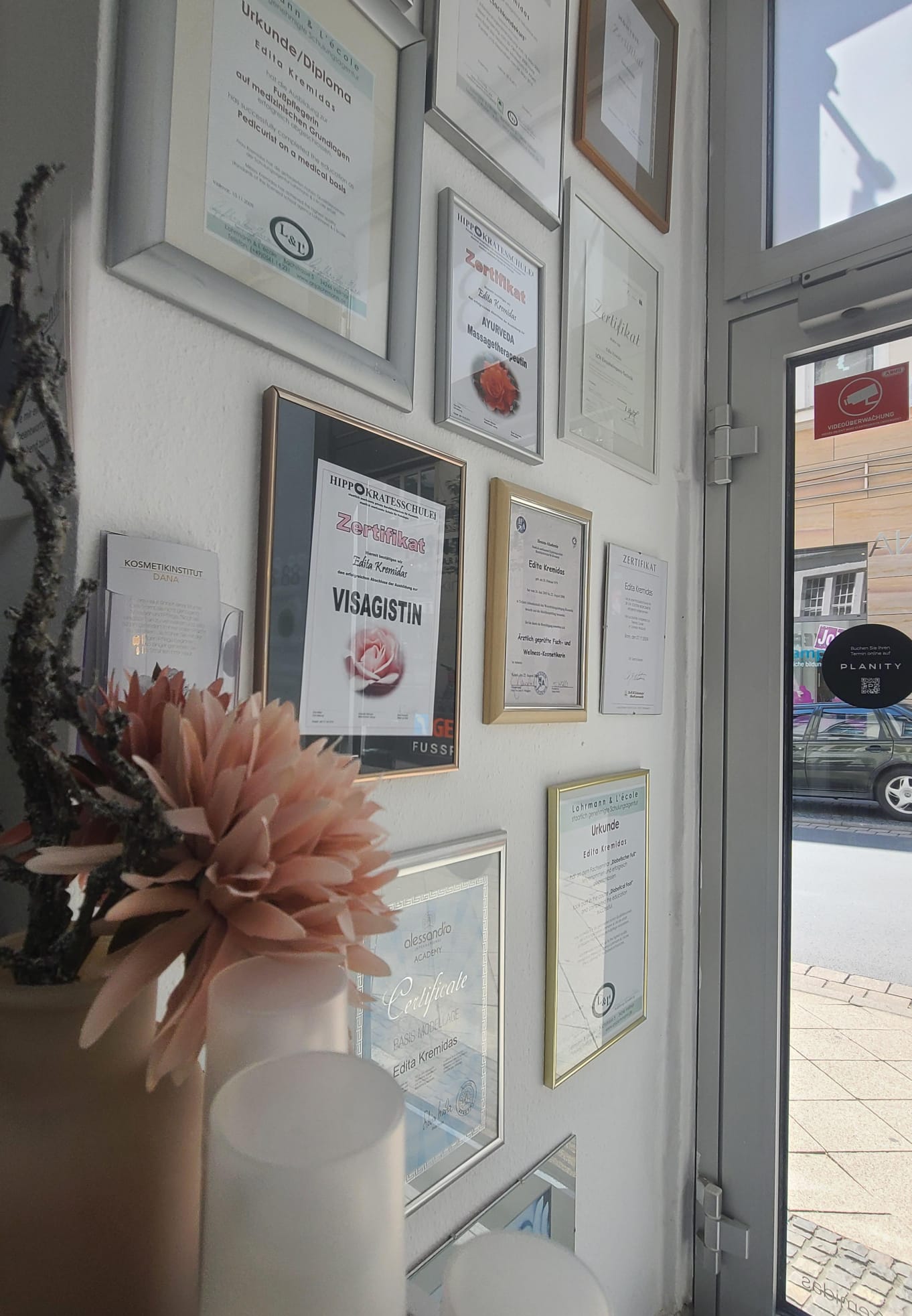 Zertifikatswand mit Urkunden und Diplomen von Edita Kremidas im Kosmetikinstitut Dana Kassel